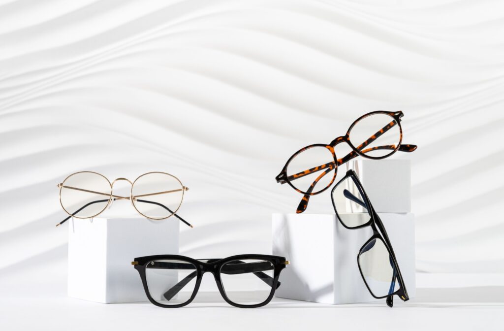 4 pairs of trendy glasses placed together on top of white boxes in front of a white background