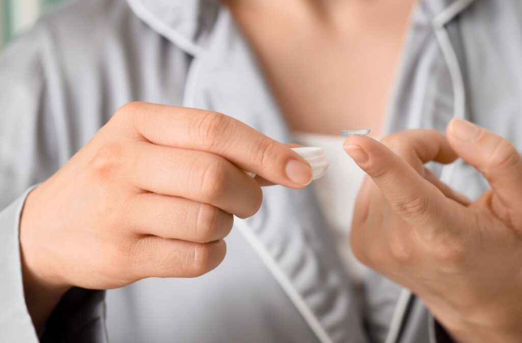 A close up of something holding a contact lens just outside of a contact lens case